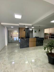 an empty lobby with a potted plant in the middle at Hotel Acauã in Campo Mourão