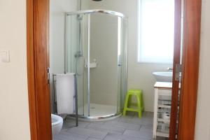a bathroom with a shower and a green stool at Faial Marina Apartments 2 in Horta +27 photos