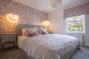 a bedroom with a large bed and a window at The Rosemont in Royal Tunbridge Wells
