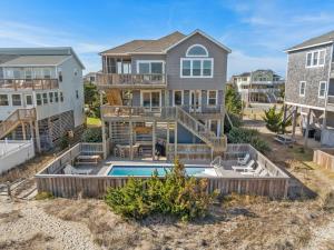 a home with a swimming pool and a house at HIWA03: Lands End in Waves