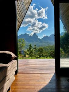 a room with a view of the mountains through a window at Chalé Serra Furada - vista única da Serra Furada in Grão Pará