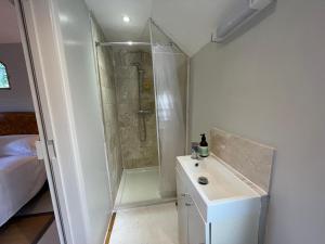 a white bathroom with a shower and a sink at The Hen House in North Huish +16 photos