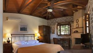 a bedroom with a bed and a ceiling fan at xenonas ton xromaton - Guest house of colors in Lafkos
