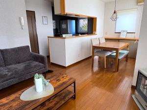 a living room with a couch and a table at Olive retreat Sapporo 札幌市南区 一軒家の1フロア貸切 5名まで 2ベッドルーム 無料駐車場 登山 スキー場への好アクセス in Sapporo