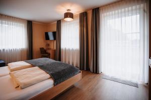 a bedroom with a bed and a large window at Landhaus Schönfelder Hof in Hollfeld