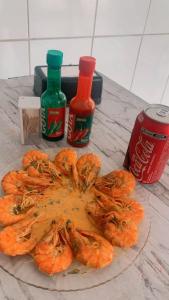 a table with a plate of shrimp and two sauces at Soberano hotel in Arapiraca