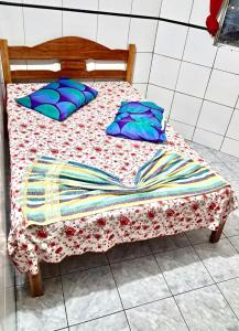 a bed with blue pillows and a blanket on it at Soberano hotel in Arapiraca