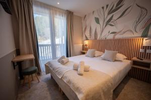 a bedroom with a large bed with towels on it at Hôtel Le Chamois d'Or, USSIM Vacances Méribel in Méribel