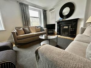 a living room with a couch and a fireplace at 3 The Townhouse in Keswick