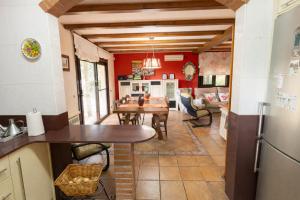 a kitchen and dining room with red walls and a table at Catalunya Casas Peaceful Perfection , only 30km from Barcelona! in Vacarisas