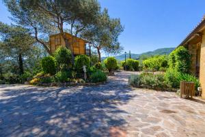 a house with a stone walkway in a garden at Catalunya Casas Peaceful Perfection , only 30km from Barcelona! in Vacarisas