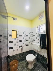 a bathroom with a toilet and a shower at panakkal tower in Guruvāyūr +4 photos