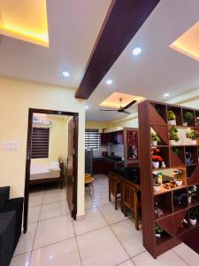 a living room and dining room with a kitchen and a dining table at panakkal tower in Guruvāyūr