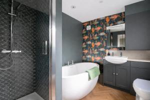a bathroom with a tub and a sink and a shower at The Rosemont in Royal Tunbridge Wells