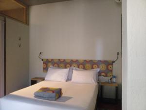a bedroom with a white bed with a yellow headboard at Travelers Nest in St Lucia