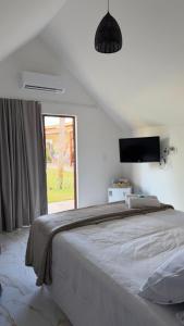 a bedroom with a large bed with a window at Pousada Vila Assu in Ceará-Mirim