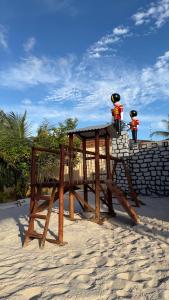a wooden picnic table on the beach in the sand at Pousada Vila Assu in Ceará-Mirim +13 photos