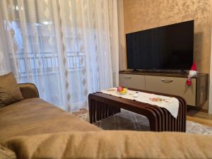 a living room with a tv and a coffee table at Apartman Mikulic 2 in Subotica