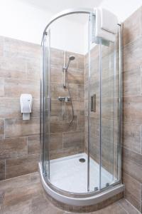 a shower with a glass door in a bathroom at Hôtel du Helder in Lyon +25 photos