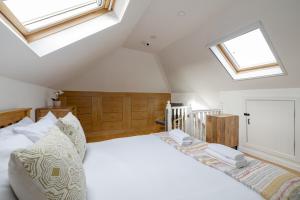 a bedroom with a white bed with skylights at Barnton Grove Getaway in Edinburgh