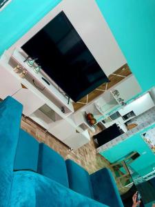 a living room with a flat screen tv and blue chairs at Chácara Betel in Marechal Deodoro