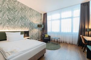 a hotel room with a bed and a chair at Hotel Arkadia in Friedrichsdorf +114 photos