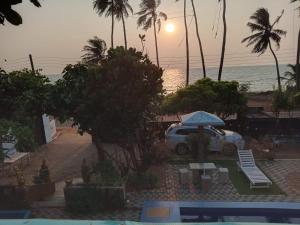 a car parked next to the beach with an umbrella at Blu EDGE BEACH RESORT in Katuneriya