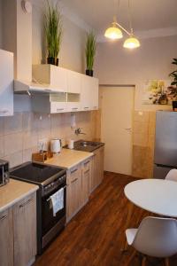 a kitchen with white cabinets and a table at Apartament Komnata 8 in Przemyśl