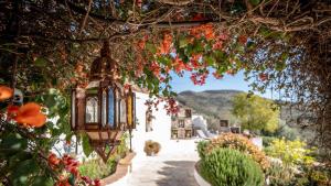a lantern hanging from a building with flowers at Finca Gran Cerros in Alora