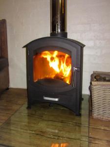 a stove with a fire in a room at Phillipskop Eco-Chalets in Stanford
