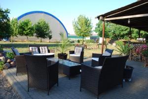 a patio with wicker chairs and tables in a yard at Ferienwohnung-Esel in Dreetz