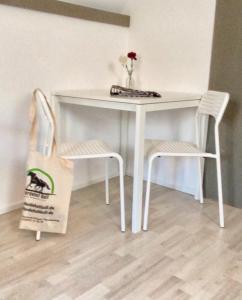 a white table and two chairs and a bag at Ferienwohnung-Esel in Dreetz
