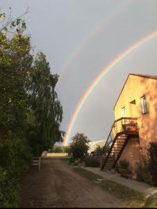 a rainbow in the sky over a house at Ferienwohnung-Esel in Dreetz +7 photos