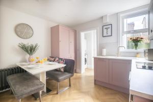 a kitchen with a table and chairs in a kitchen at The Rosemont in Royal Tunbridge Wells