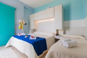 a room with two beds with towels on a table at Hotel Mercedes in Misano Adriatico +33 photos