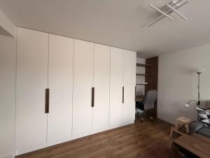a living room with white cabinets and a desk at Lipa Apartmán in Tlmače