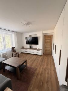 a living room with a flat screen tv and a table at Lipa Apartmán in Tlmače