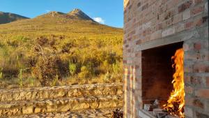 a brick oven with fire in it in a field at Phillipskop Eco-Chalets in Stanford