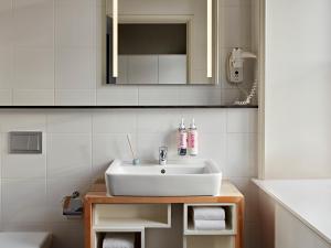 a bathroom with a white sink and a mirror at YAYS Amsterdam Maritime by Numa in Amsterdam