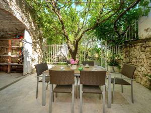 une table et des chaises avec un arbre en arrière-plan dans l'établissement Lovely Mediterranean home near the beach, à Cavtat