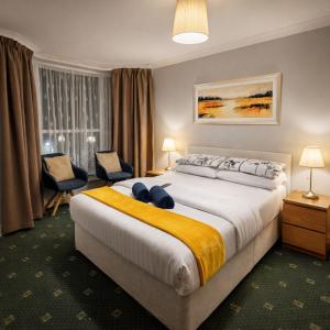 a hotel room with a large bed and a chair at Denville Hotel in Blackpool