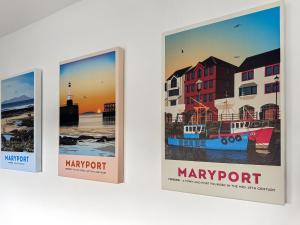a group of three posters hanging on a wall at Ritson Wharf in Maryport