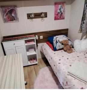 a small bedroom with a bed and a dresser at Mobil home in Biscarrosse