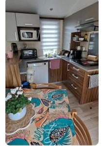 a kitchen with a table with a table cloth on it at Mobil home in Biscarrosse