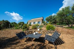 a table and chairs in front of a building at Villa CAMILLE in Ersa