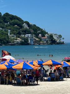 a group of umbrellas and chairs on a beach at Villa Di Verona Charm Hotel in Guarujá