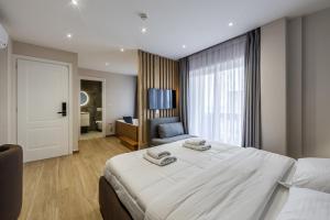 a bedroom with a large white bed and a couch at Sea La Vie Suites in Golem