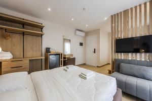 a bedroom with a large bed and a couch at Sea La Vie Suites in Golem