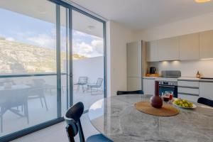 a kitchen and dining room with a table and chairs at GOZO DIVE Residence in Xlendi