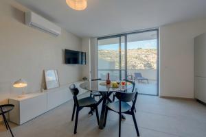 a kitchen and dining room with a table and chairs at GOZO DIVE Residence in Xlendi
